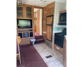 A kitchen with wooden cabinets and a black stove top oven.