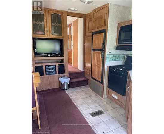 A kitchen with wooden cabinets and a black stove top oven.