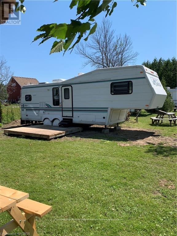 A white RV is parked in a grassy area.