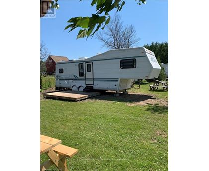 A white RV is parked in a grassy area.
