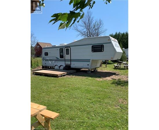 A white RV is parked in a grassy area.
