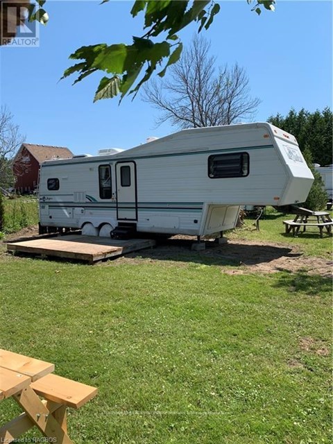 A white RV is parked in a grassy area.