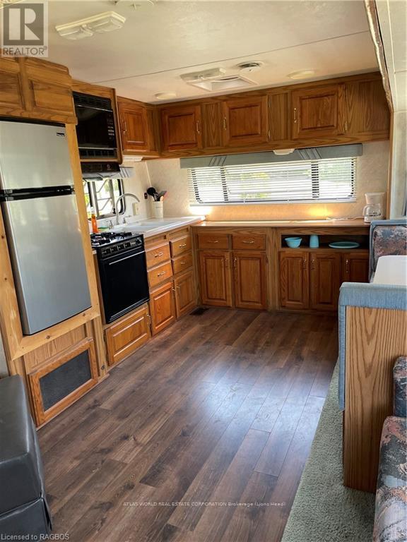 A kitchen with wooden cabinets and a refrigerator.