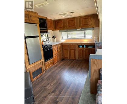 A kitchen with wooden cabinets and a refrigerator.