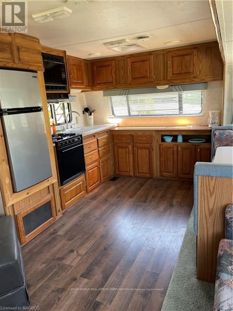 A kitchen with wooden cabinets and a refrigerator.