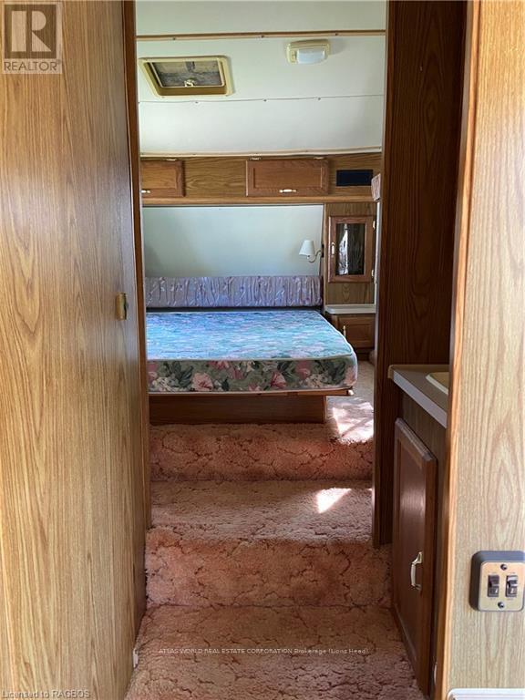 A bedroom with a bed, dresser, and a window.
