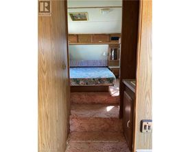 A bedroom with a bed, dresser, and a window.