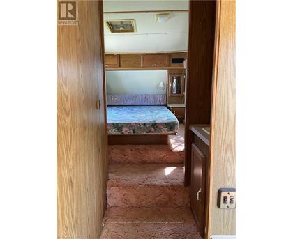 A bedroom with a bed, dresser, and a window.