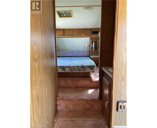 A bedroom with a bed, dresser, and a window.