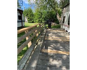 A wooden fence runs along the side of a concrete walkway.