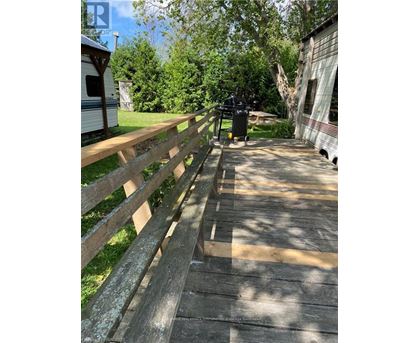 A wooden fence runs along the side of a concrete walkway.