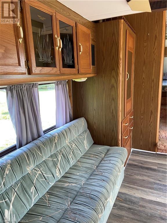 A living room with a couch and wooden cabinets.