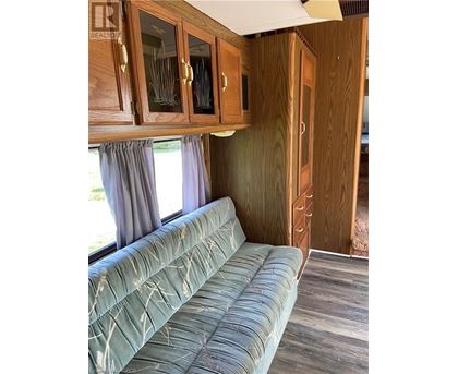 A living room with a couch and wooden cabinets.