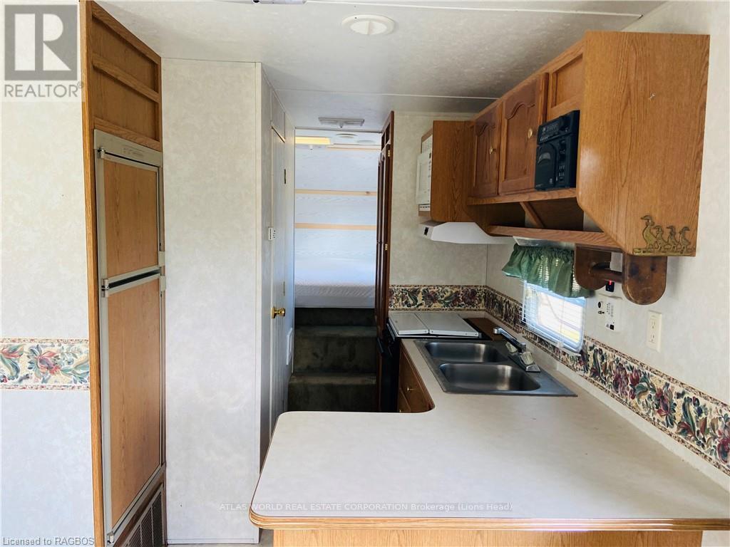 A kitchen with a sink and a refrigerator.