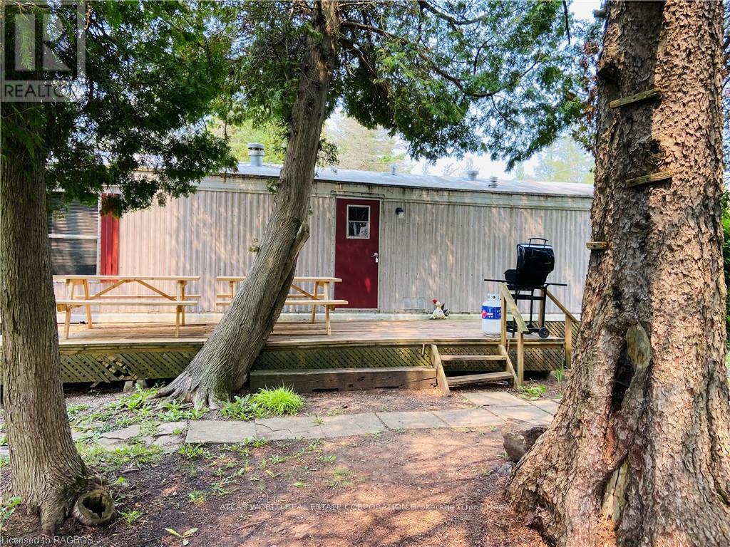 A red door is on a building with a picnic table in front of it.