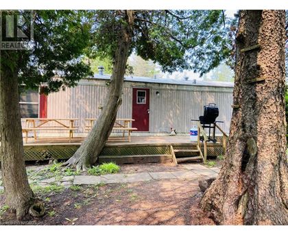A red door is on a building with a picnic table in front of it.