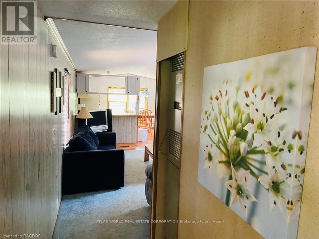 A living room with a couch and a painting of lilies on the wall.