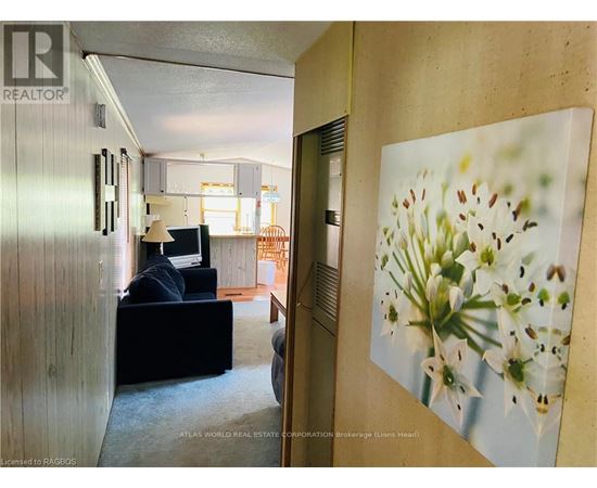 A living room with a couch and a painting of lilies on the wall.