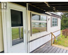 A white door and window on a house with a wooden deck.