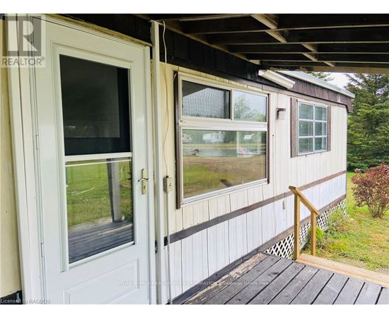 A white door and window on a house with a wooden deck.
