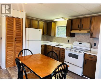 A kitchen with a table and chairs.