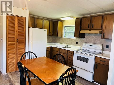 A kitchen with a table and chairs.