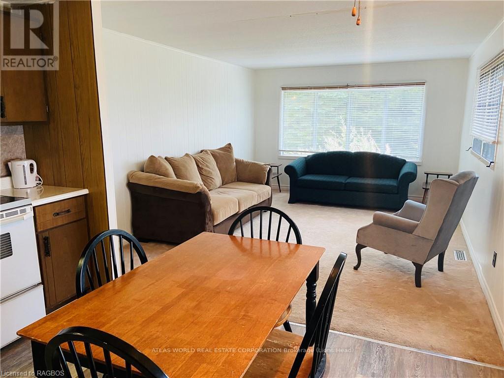 A living room with a black couch and a wooden table.