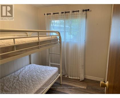 A bedroom with bunk beds and a window with curtains.