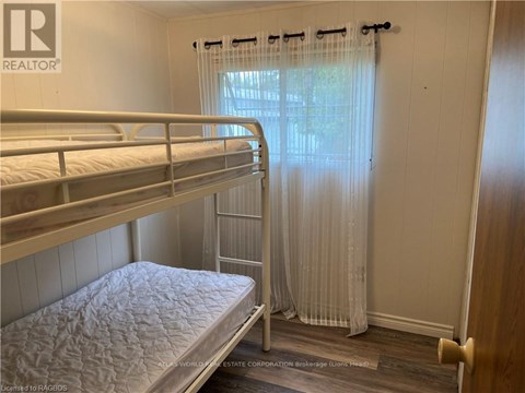 A bedroom with bunk beds and a window with curtains.