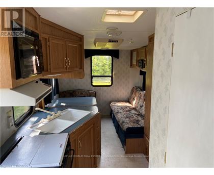 A kitchen area with a sink and microwave.