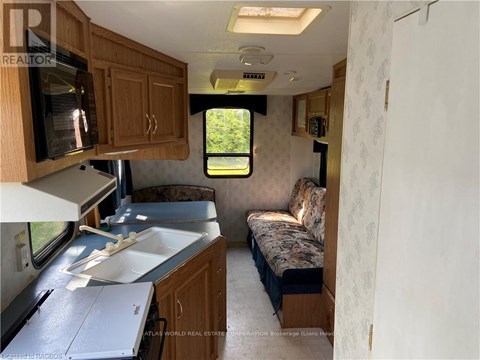 A kitchen area with a sink and microwave.