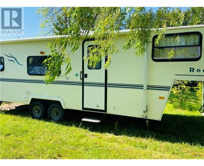 A white RV is parked in a grassy area.