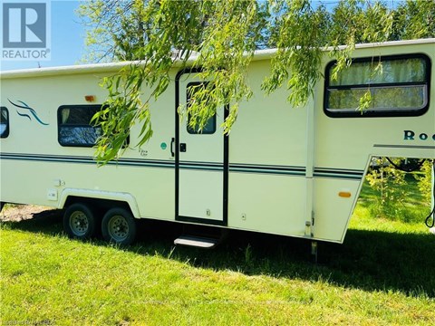 A white RV is parked in a grassy area.