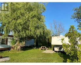 A white RV is parked in a grassy area next to a picnic table.