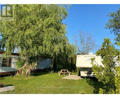 A white RV is parked in a grassy area next to a picnic table.