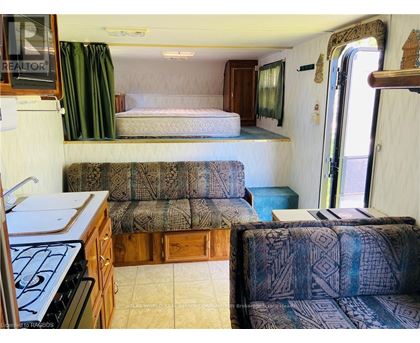 A living room with a couch and a bed in a trailer.
