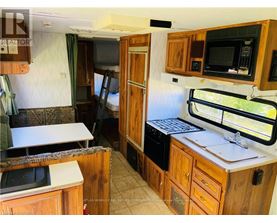 A kitchen area with wooden cabinets and a microwave.
