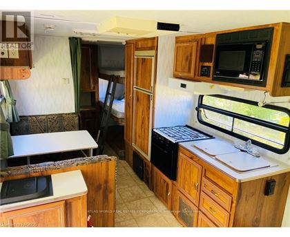 A kitchen area with wooden cabinets and a microwave.