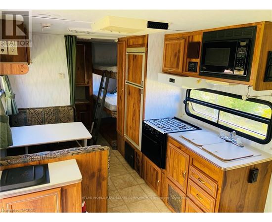 A kitchen area with wooden cabinets and a microwave.
