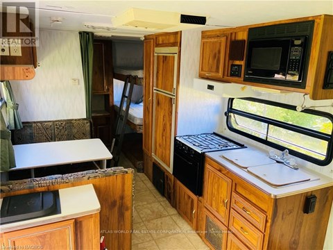 A kitchen area with wooden cabinets and a microwave.