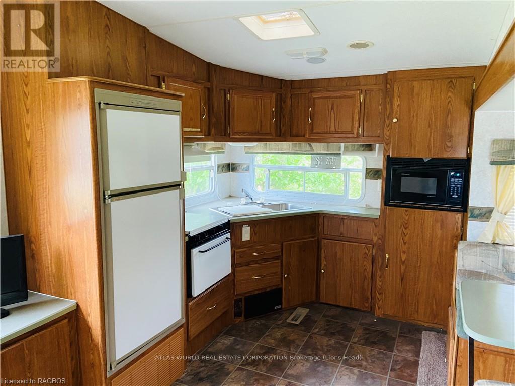 A kitchen with wooden cabinets and a white refrigerator.