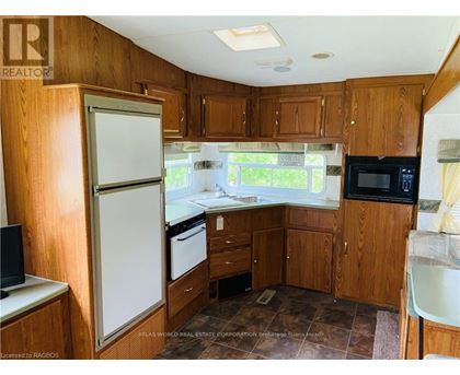 A kitchen with wooden cabinets and a white refrigerator.