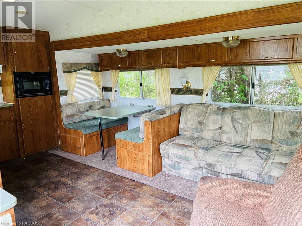 A living room with a couch, chair, and a microwave.