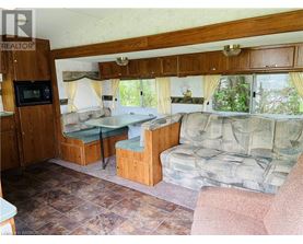 A living room with a couch, chair, and a microwave.