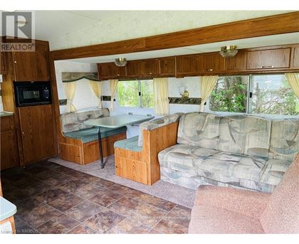 A living room with a couch, chair, and a microwave.
