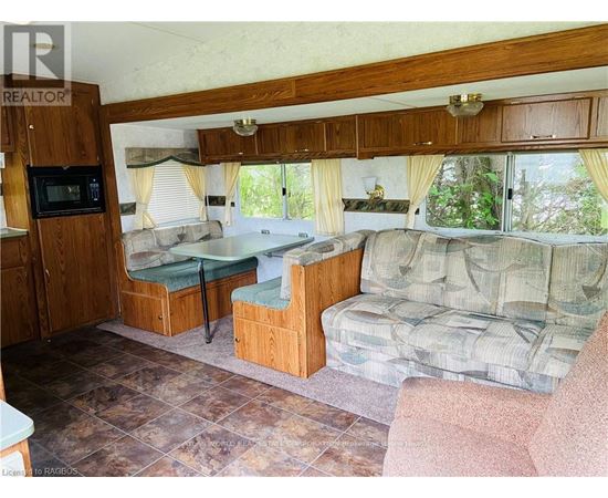 A living room with a couch, chair, and a microwave.