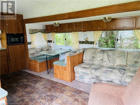 A living room with a couch, chair, and a microwave.