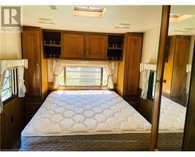 A bedroom with a large bed and wooden cabinets.