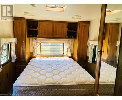 A bedroom with a large bed and wooden cabinets.