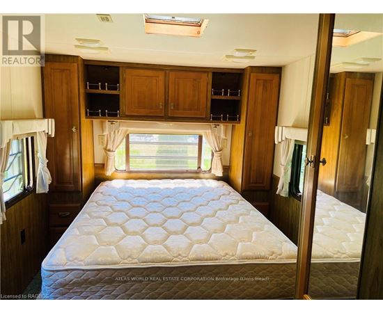 A bedroom with a large bed and wooden cabinets.